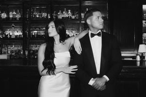 A black and white wedding reception photo showing people in formal attire at an evening celebration.
