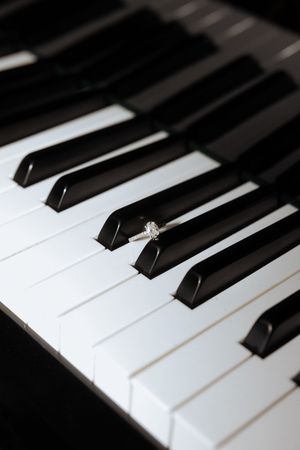 Close-up view of black and white piano keys with dramatic lighting and shallow depth of field.