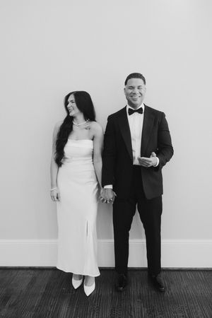 Artistic black and white photo series showing a couple posing playfully against a white wall.
