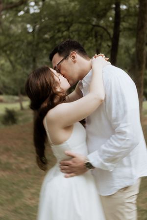 A romantic embrace between two people in a garden wearing white, captured in an artistic sequence of photos.