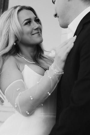 A tender black and white wedding moment with a couple in bridal attire sharing an intimate close-up.