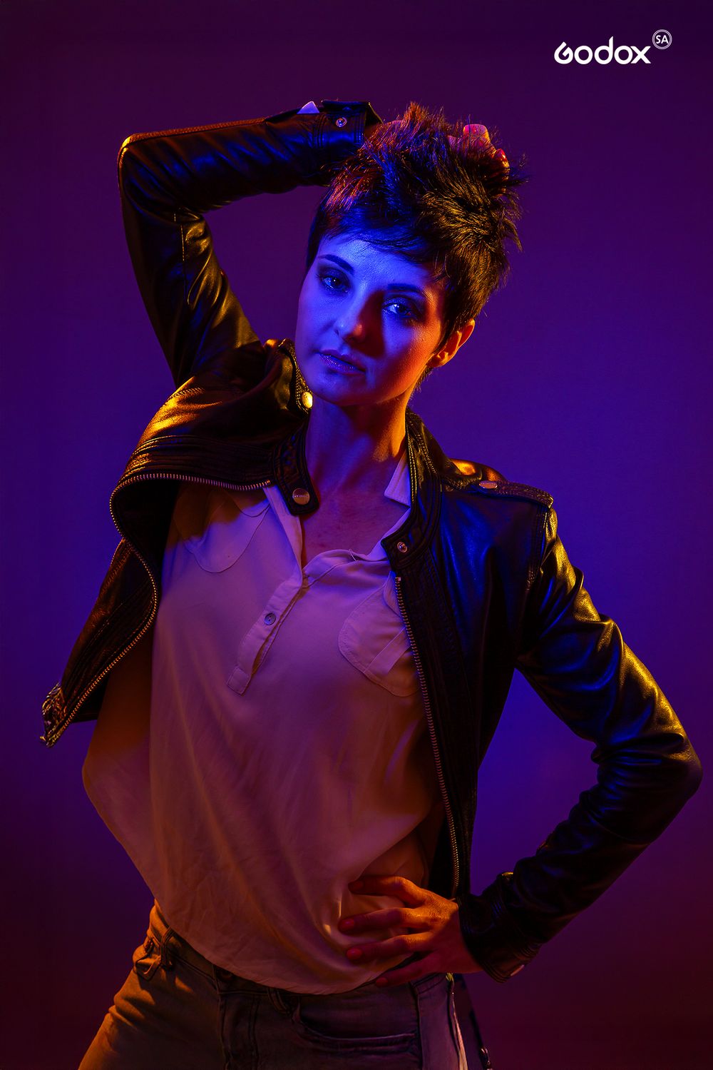A dramatic artistic portrait in dark purple lighting showing dynamic poses against a moody backdrop with Godox logo visible.