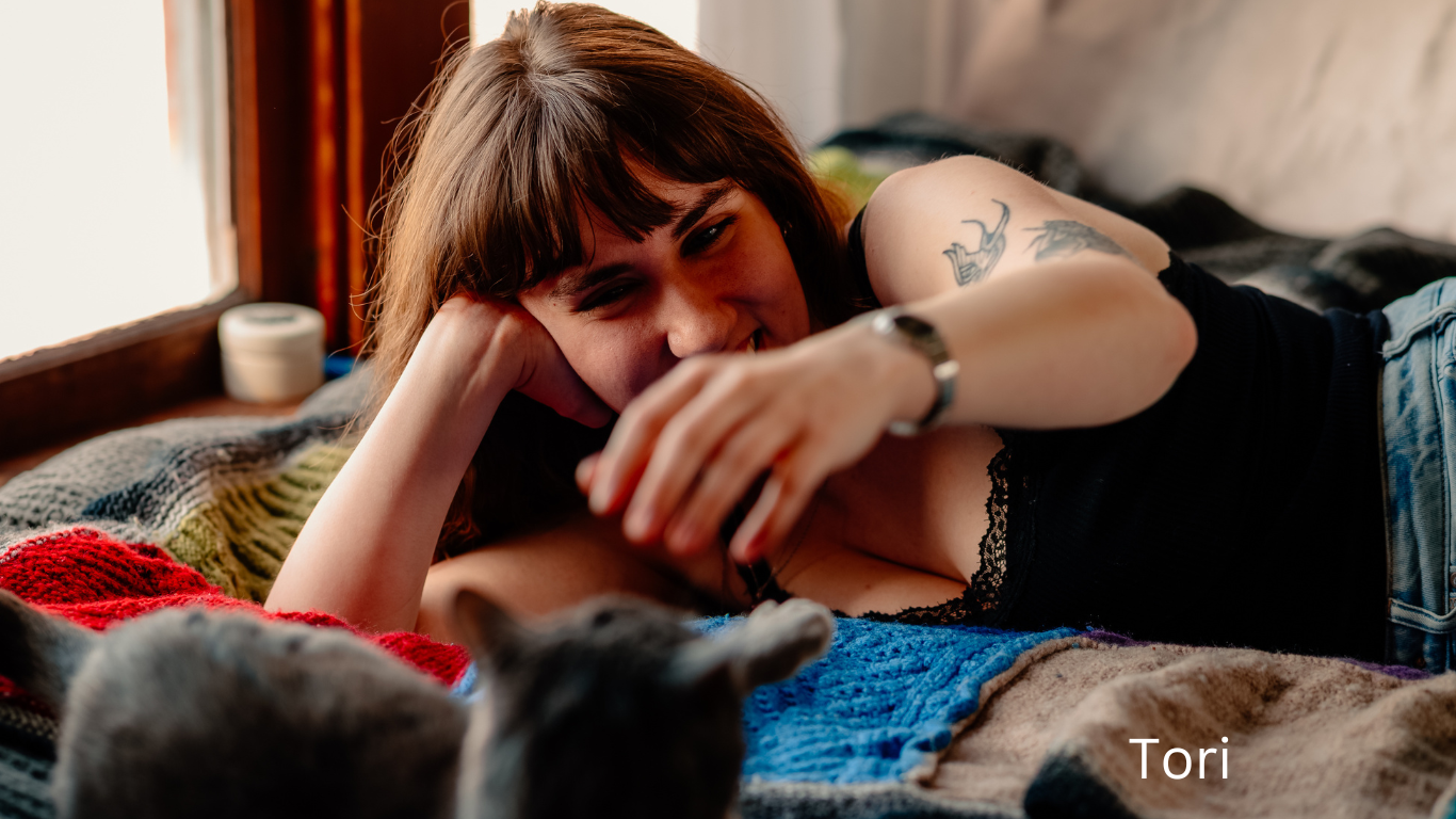 A person relaxing on a couch with a black cat, enjoying a cozy moment at home.