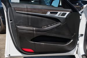 Interior door panel of a luxury car with wood trim and power window controls.