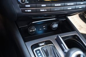 Vehicle interior showing automatic gear shifter and climate control panel with dual temperature knobs in center console.