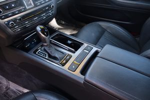 Luxury car interior center console featuring black leather, automatic transmission and electronic controls.