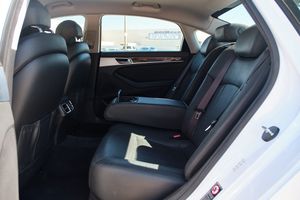 Clean black leather interior backseat of a luxury vehicle with ample legroom and armrest.