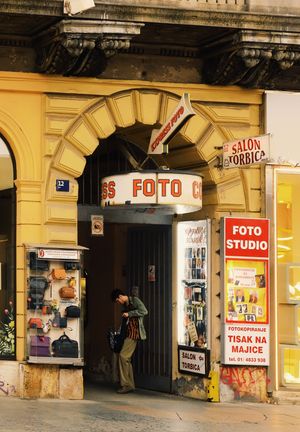 Vintage photo studio storefront with yellow facade and retro signage in an old European building.