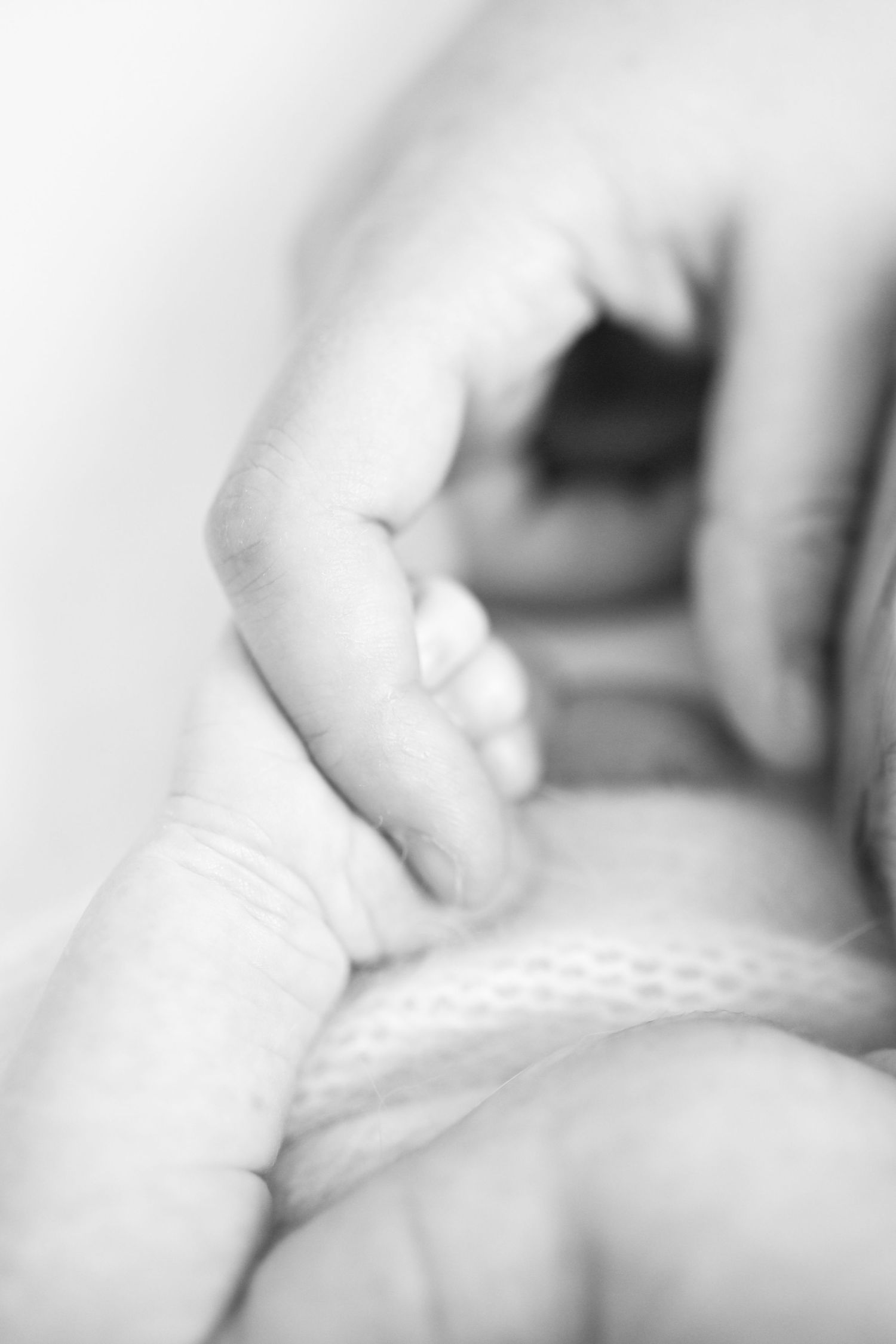 Black and white macro shot of a baby's tiny foot.