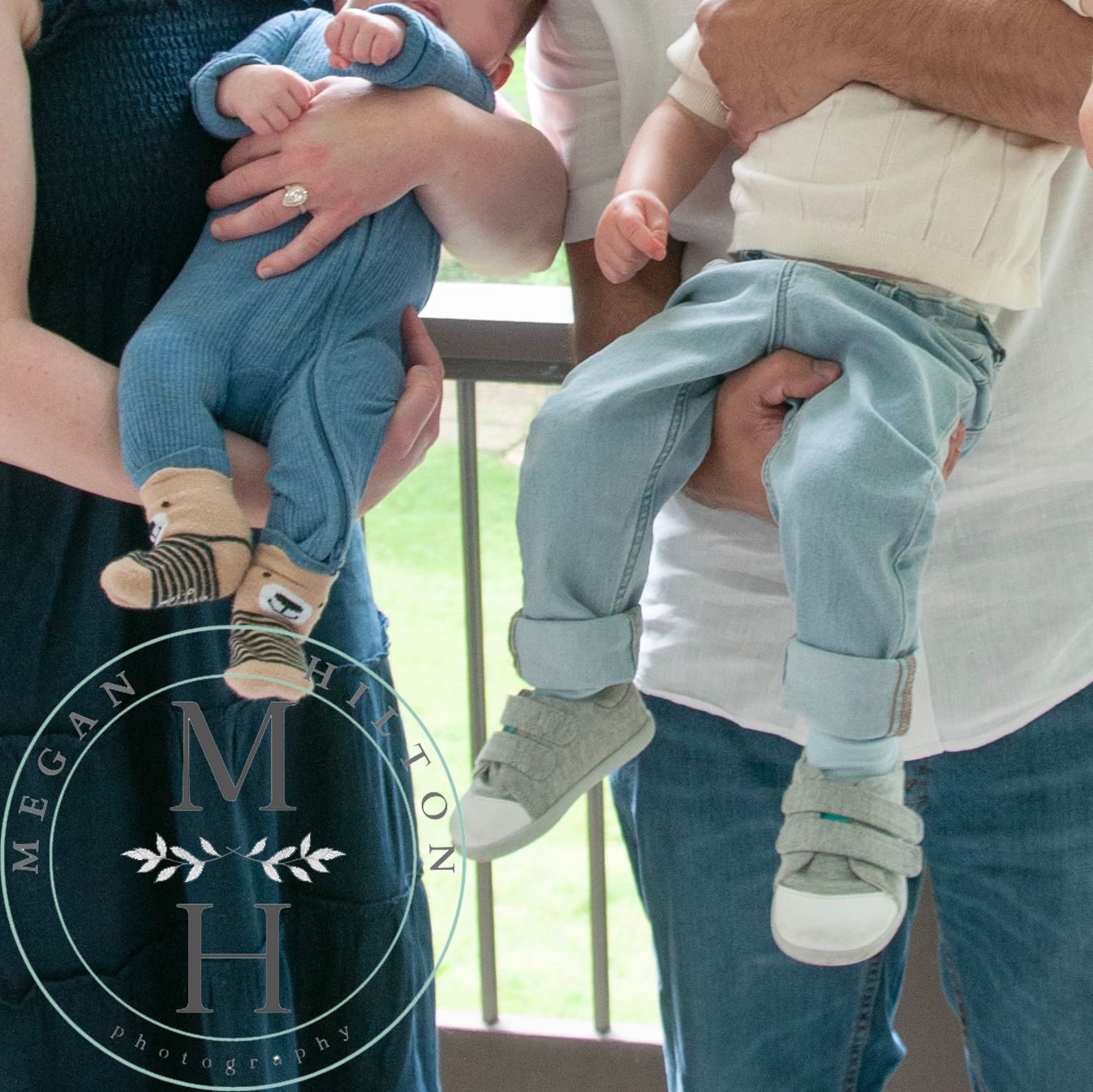 Two sets of baby feet wearing soft gray sneakers shown side by side against a light background.
