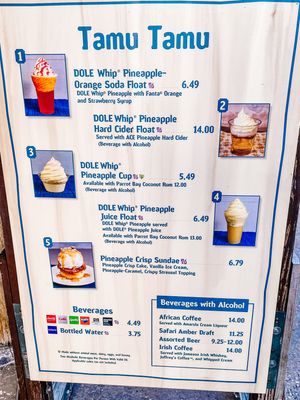 A menu board displays Tamu Tamu restaurant offerings including Dole Whip pineapple treats and beverage prices.