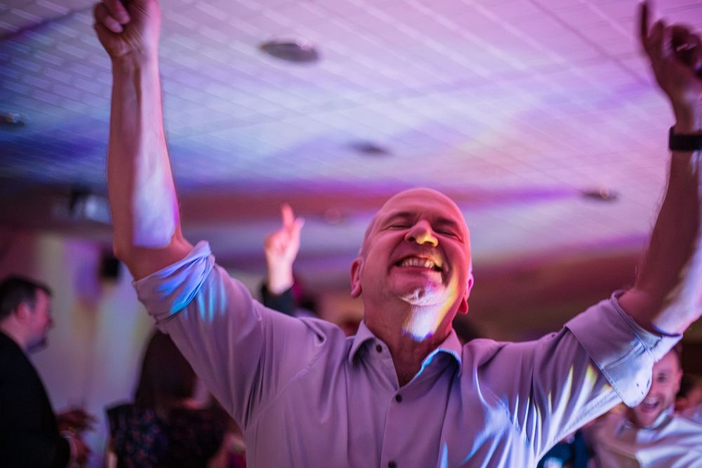 Moment of jubilation and joy as a man dances with eyes closed and hands in the air at the disco of a sports awards night at Redditch Hockey.