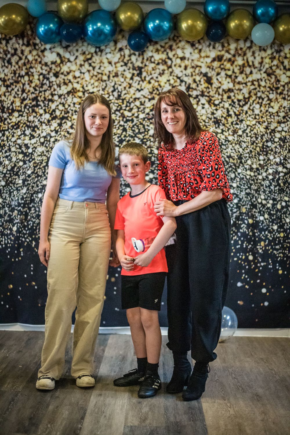 Coaches stood either side of a junior hockey player receiving an award at a Sports Awards Night.