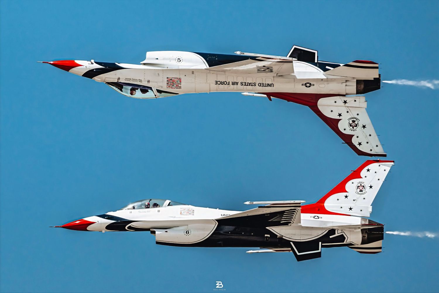 Two USAF Thunderbirds flying close with one jet upside down