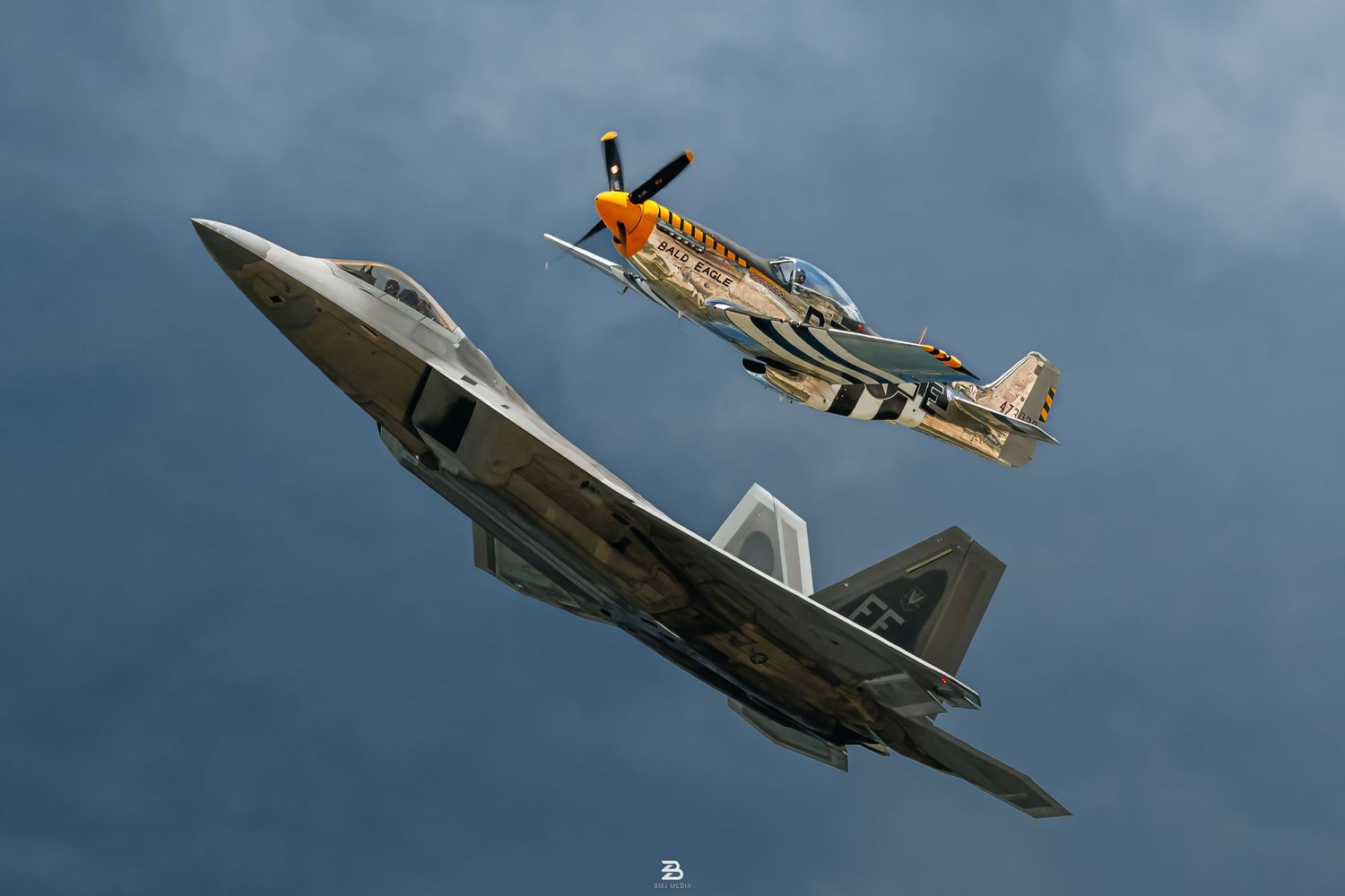 F-22 Raptor and vintage P-51 Mustang flying together in tribute formation