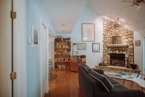 Cozy living room interior with stone fireplace, hardwood floors, built-in bookshelves and warm lighting.