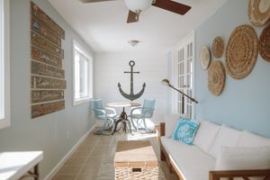 A coastal-themed living space with woven wall decor, an anchor design, and turquoise accents.