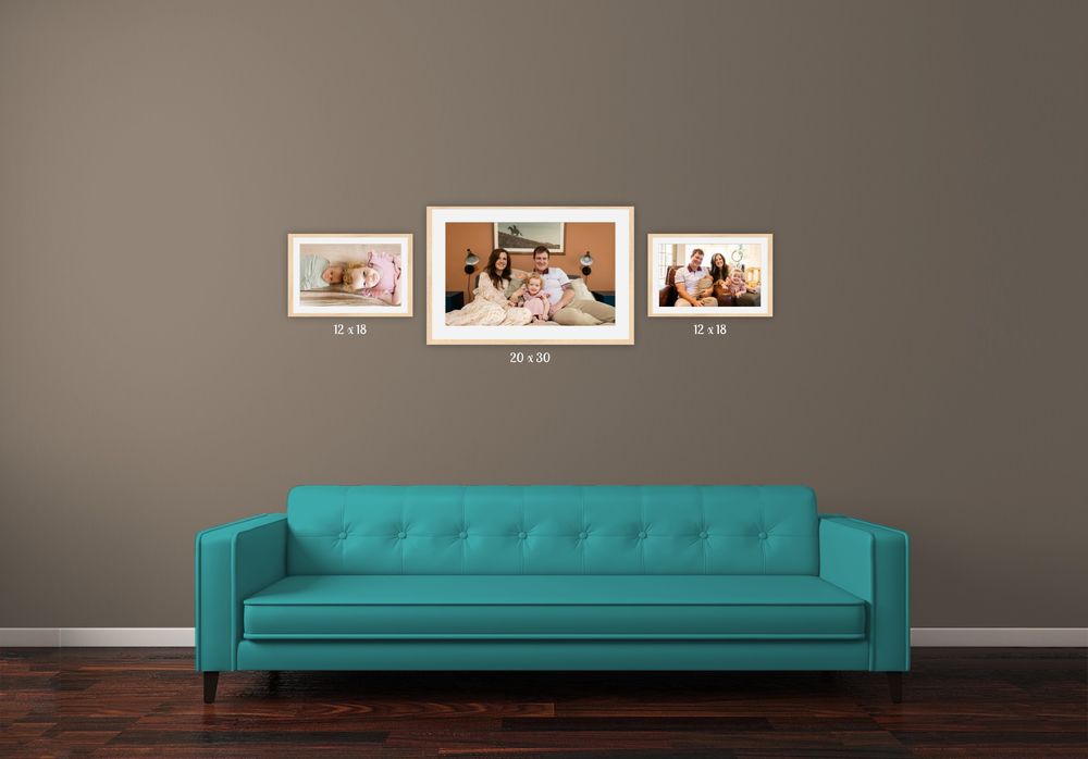 A modern teal tufted sofa sits elegantly against a gray wall with framed artwork displayed above.