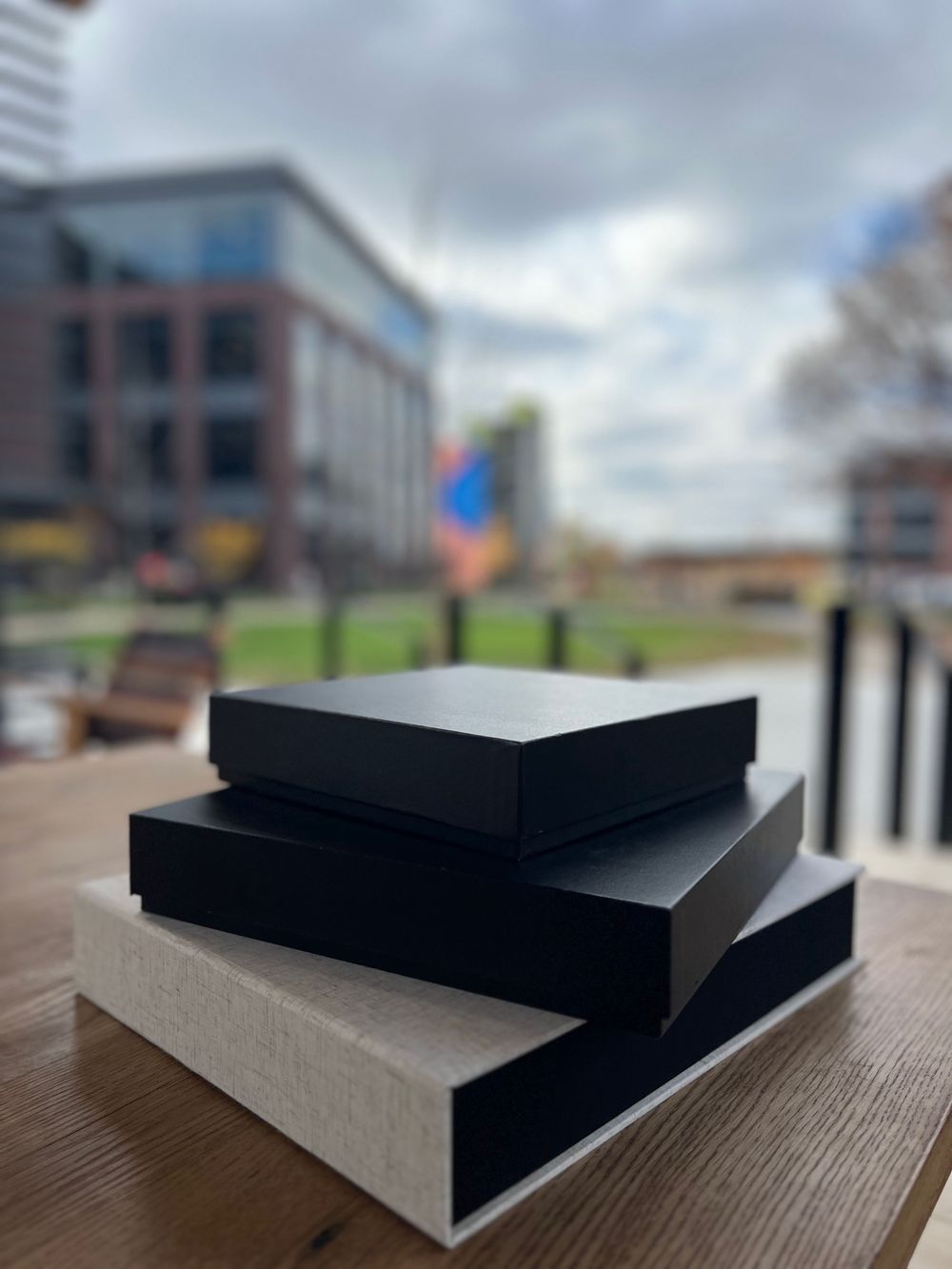 A series of black and gray architectural model blocks arranged to show different angles and perspectives on a wooden surface.