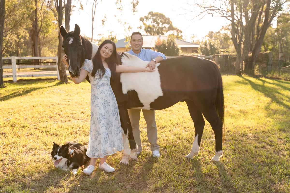 beautiful golden hour sun flair, a horse photoshoot on a private property in the hills district in western sydney of a couple and a dog