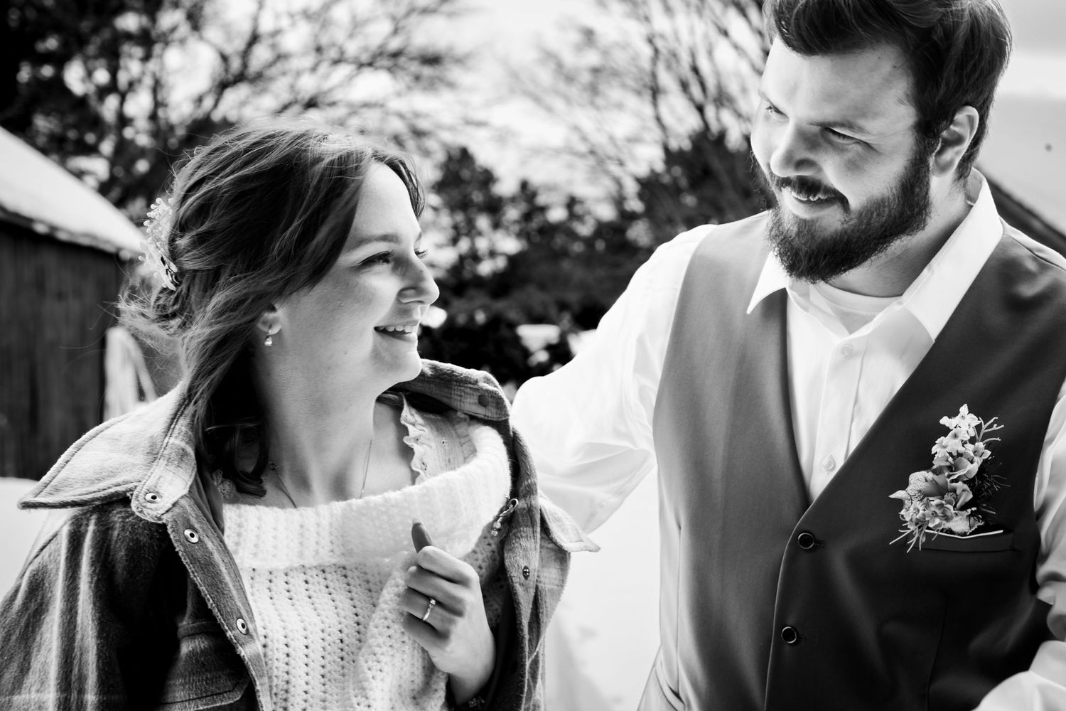 A bride and groom share a romantic kiss during their outdoor wedding ceremony with a soft, ethereal background.