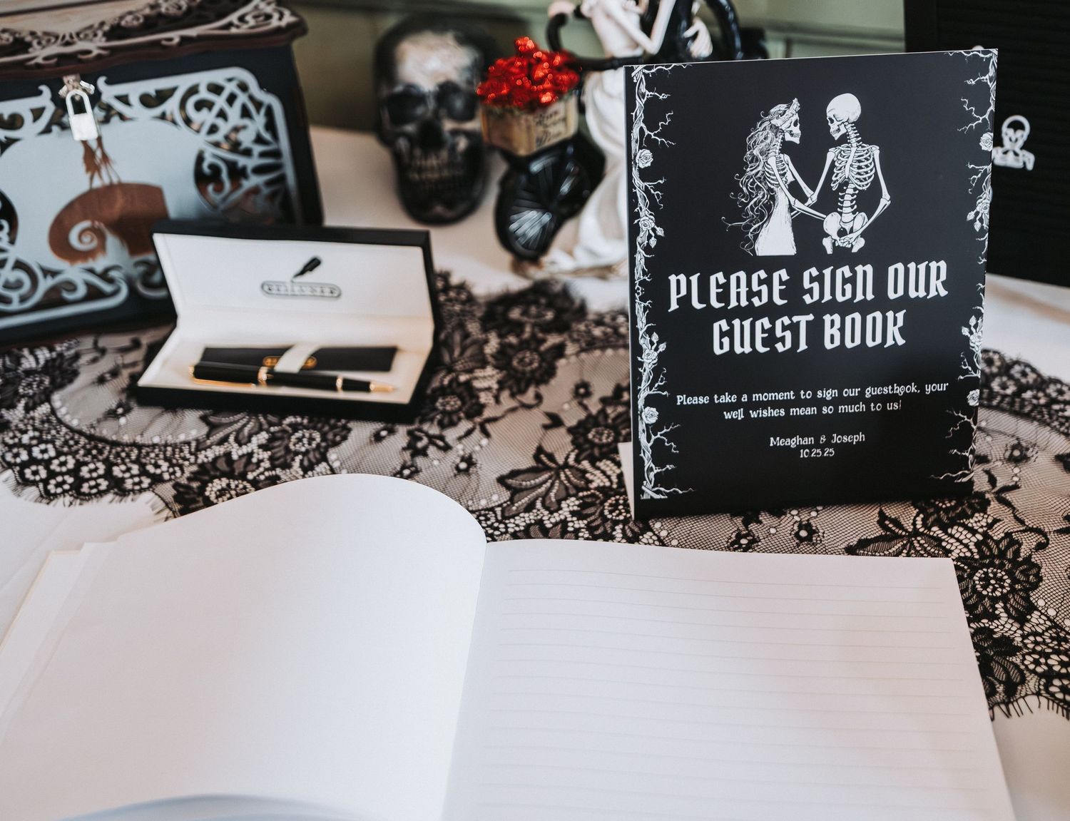 Black and white themed wedding guest book sign with elegant damask pattern decorations on display table.