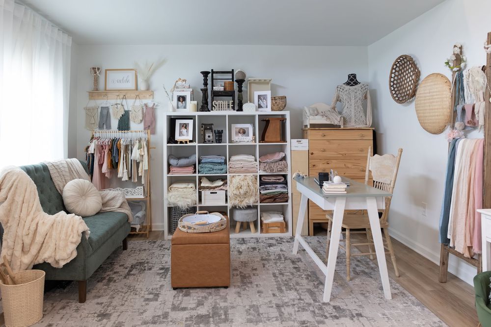 A panoramic view of a bright, minimalist fashion studio with clothing racks, mannequins, and photography equipment.