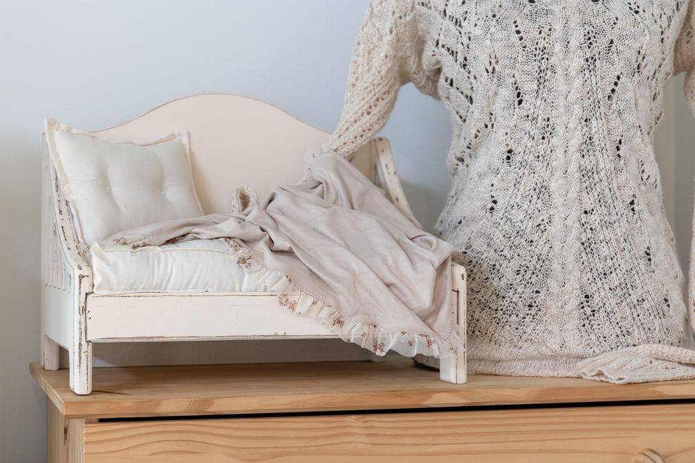 A collection of delicate white lace curtains and textiles arranged on wooden surfaces in a vintage style display.