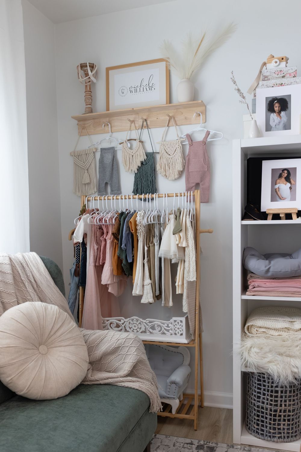 Modern minimalist bedroom with clothing rack, plush seating, and neutral decor in beige and white tones.