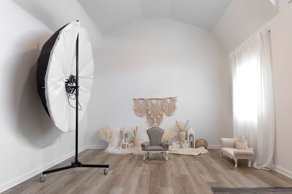 A modern white interior space with curved walls and wooden flooring features minimalist architectural elements and lighting.