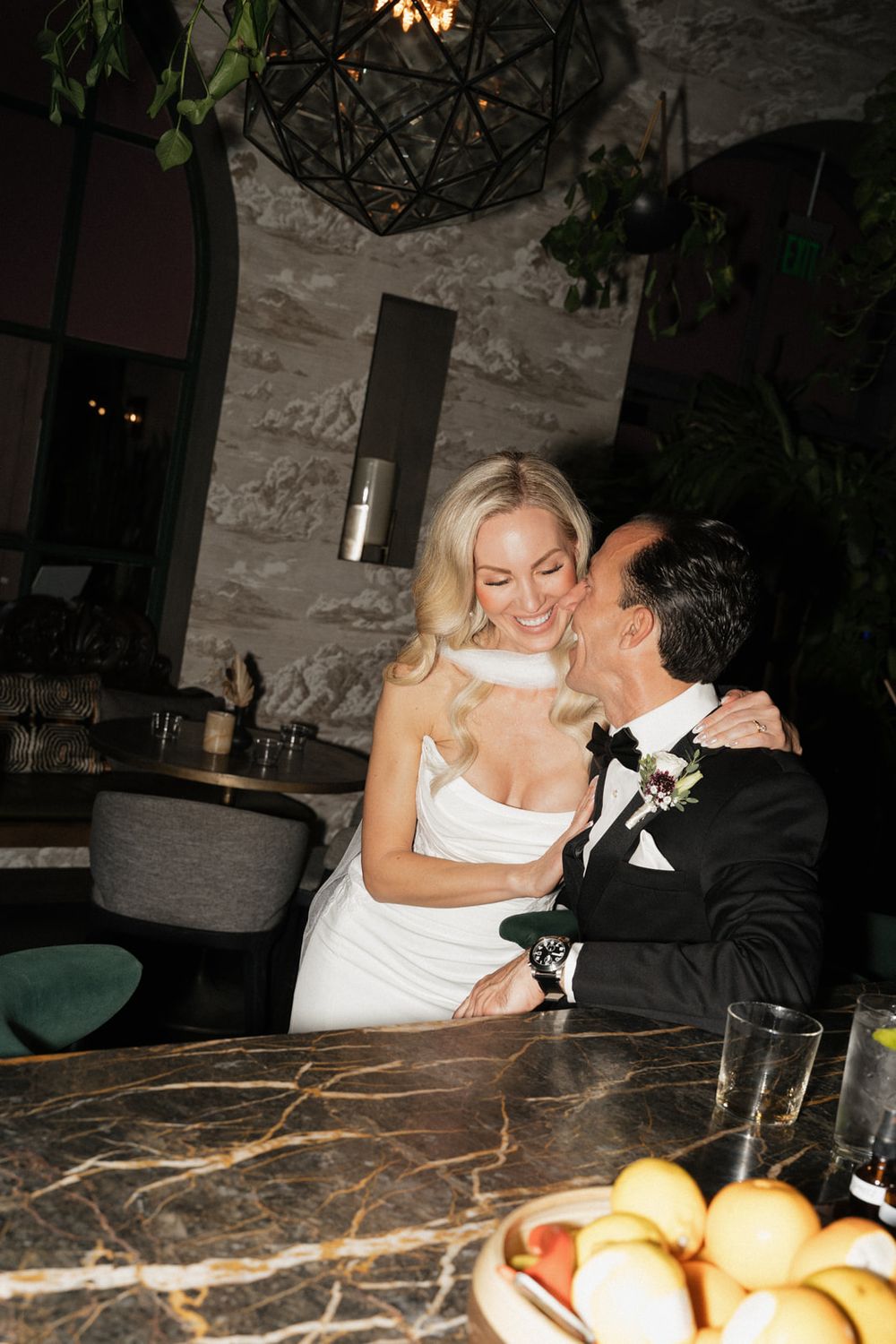 A romantic moment captured at a restaurant with a marble table and warm lighting.
