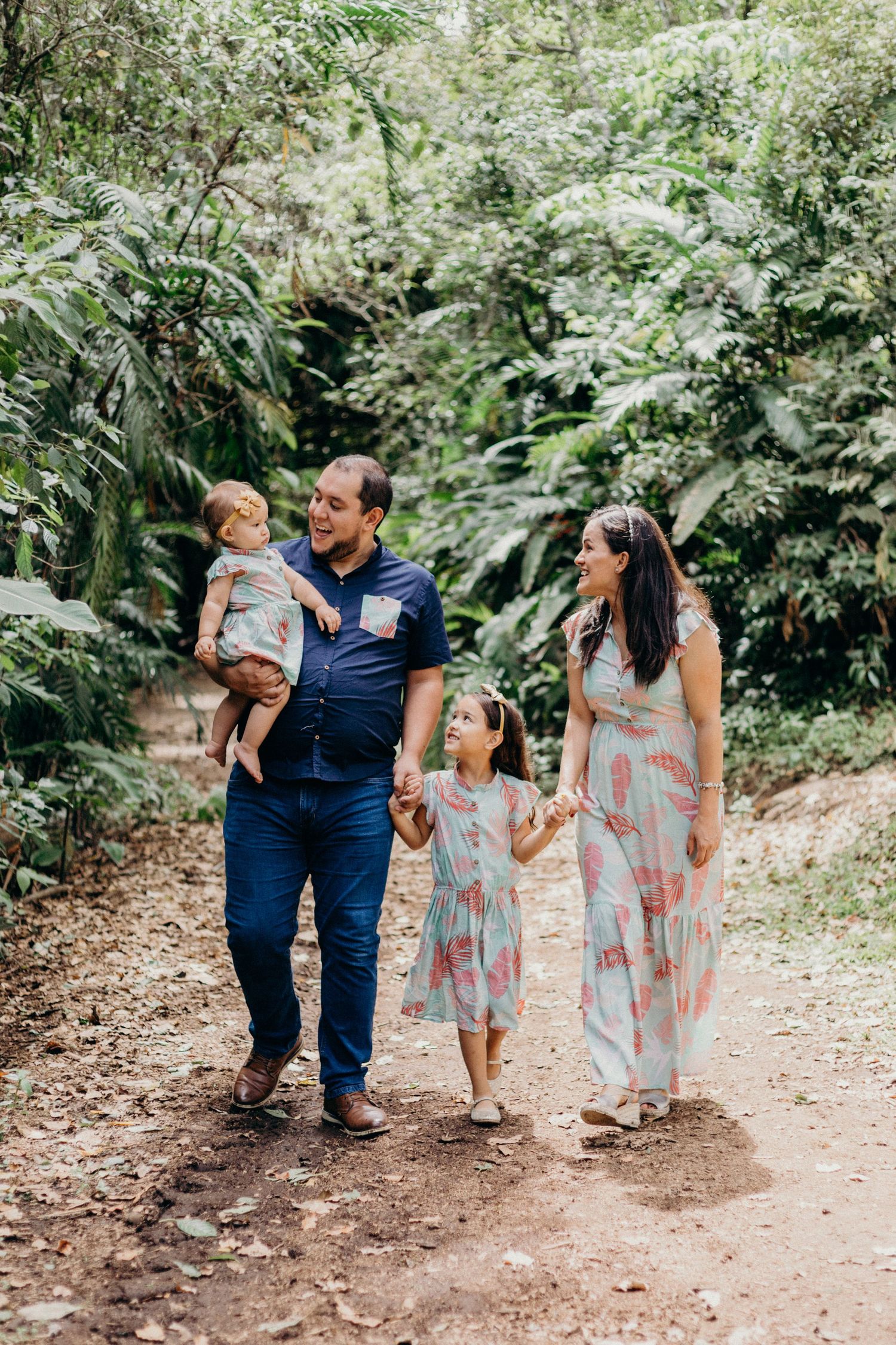 Family strolling together on a forest path surrounded by tropical greenery.