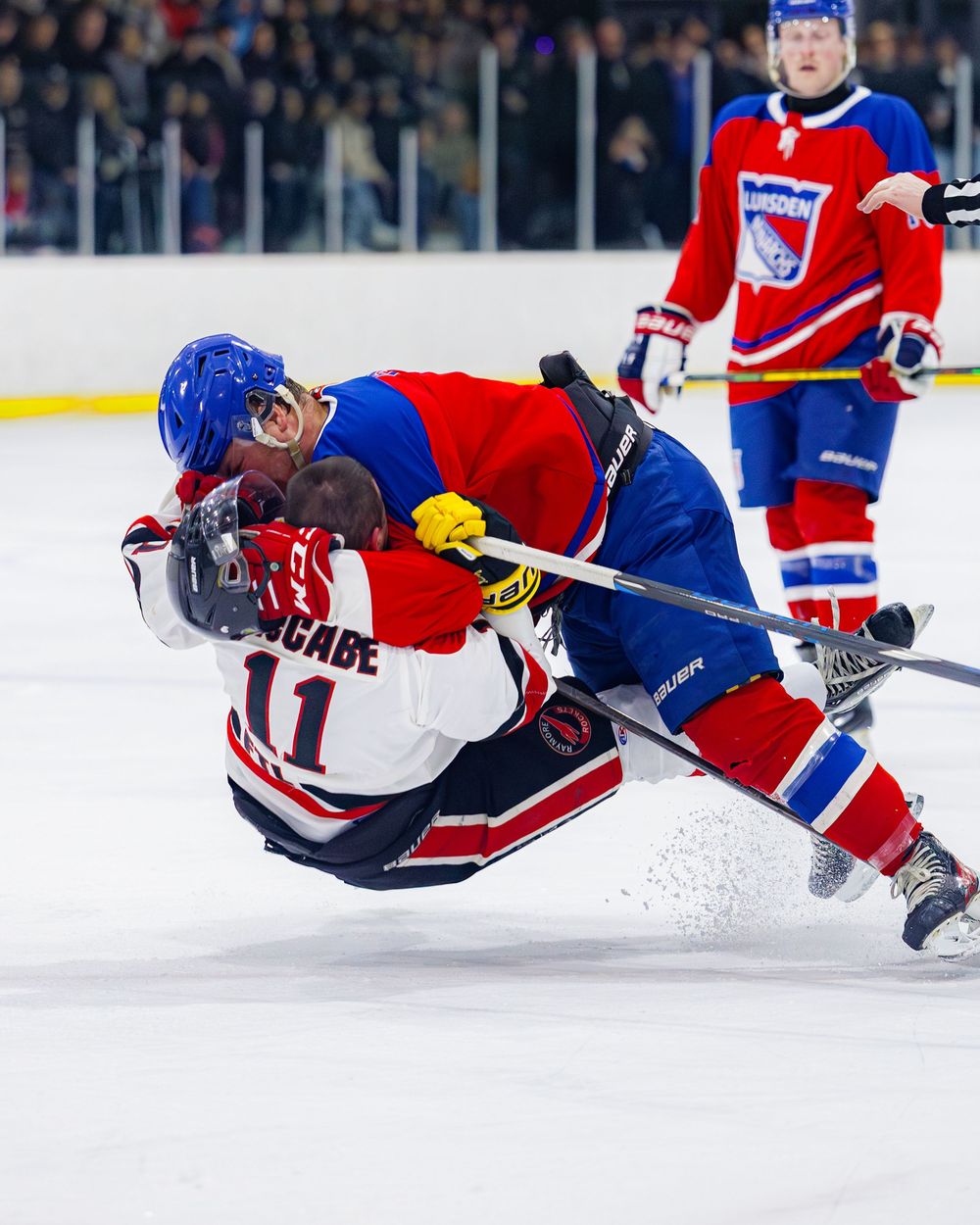 Lumsden Monarchs player delivers a powerful hit to opponent number 11 McCabe during an ice hockey game.