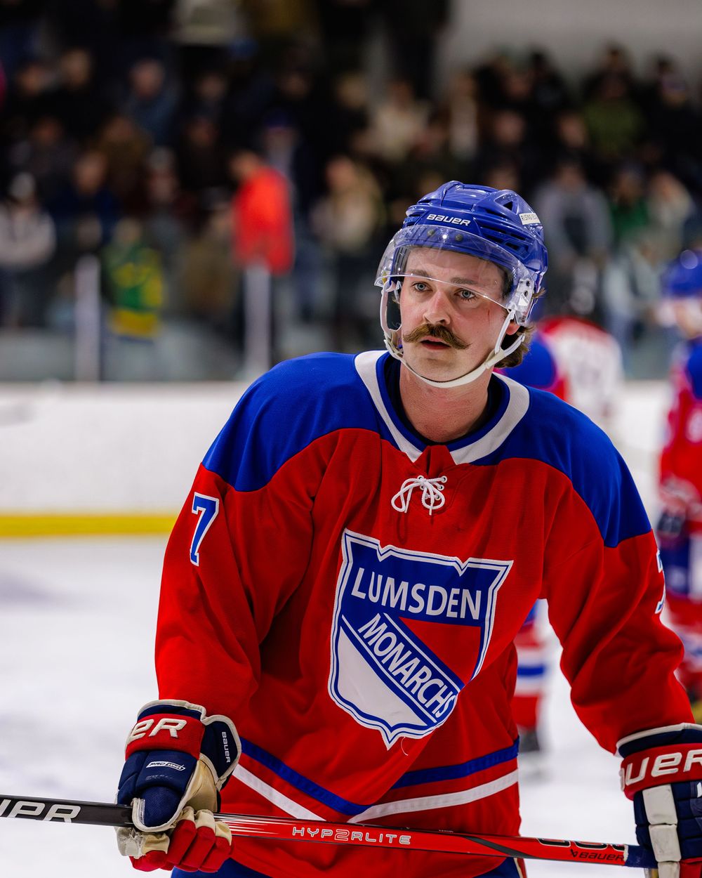 Lumsden Monarchs hockey player number 7 with a mustache skating on ice during a hockey game.