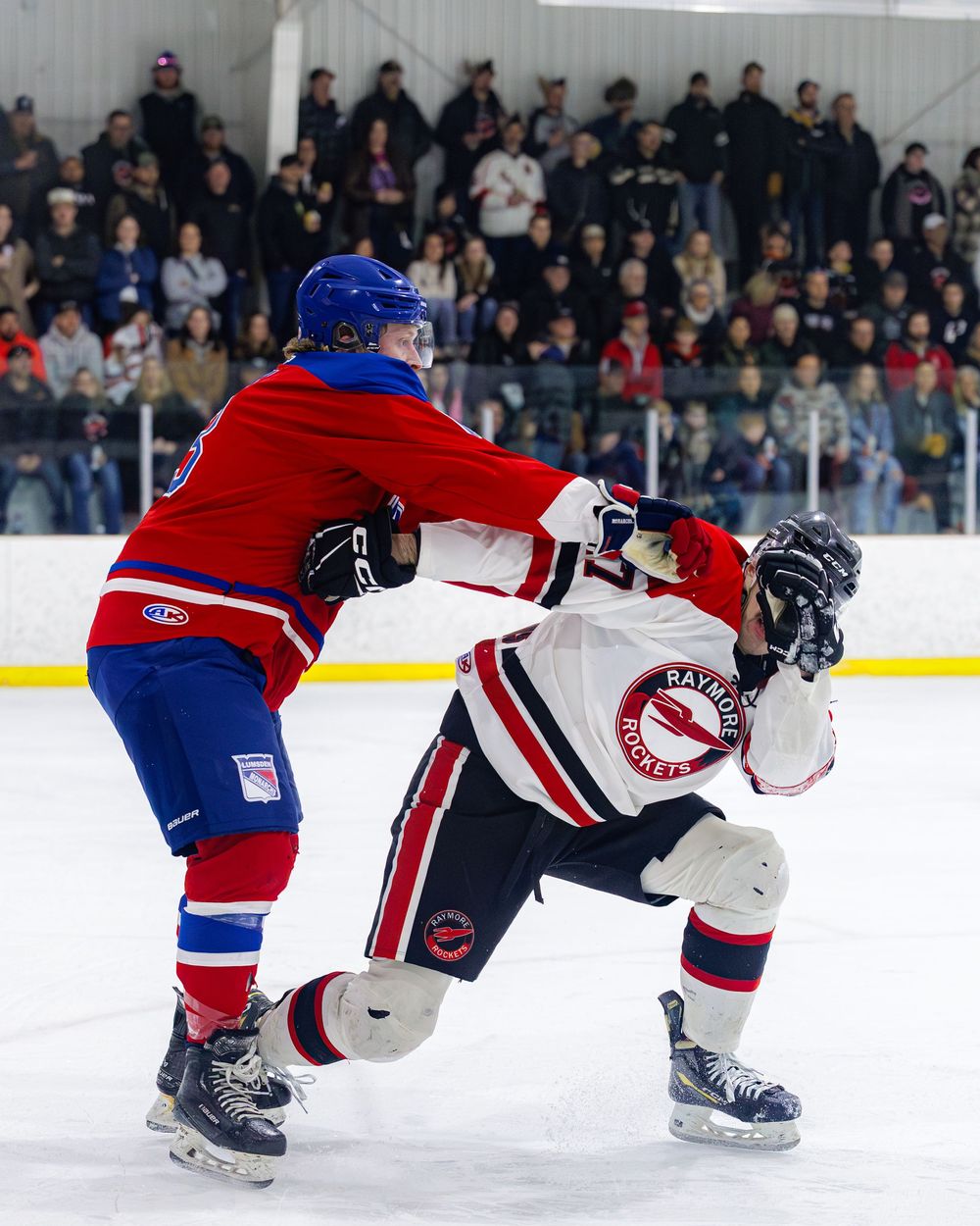 Lumsden Monarchs player delivers a hard check to opposing team player during a physical hockey game.
