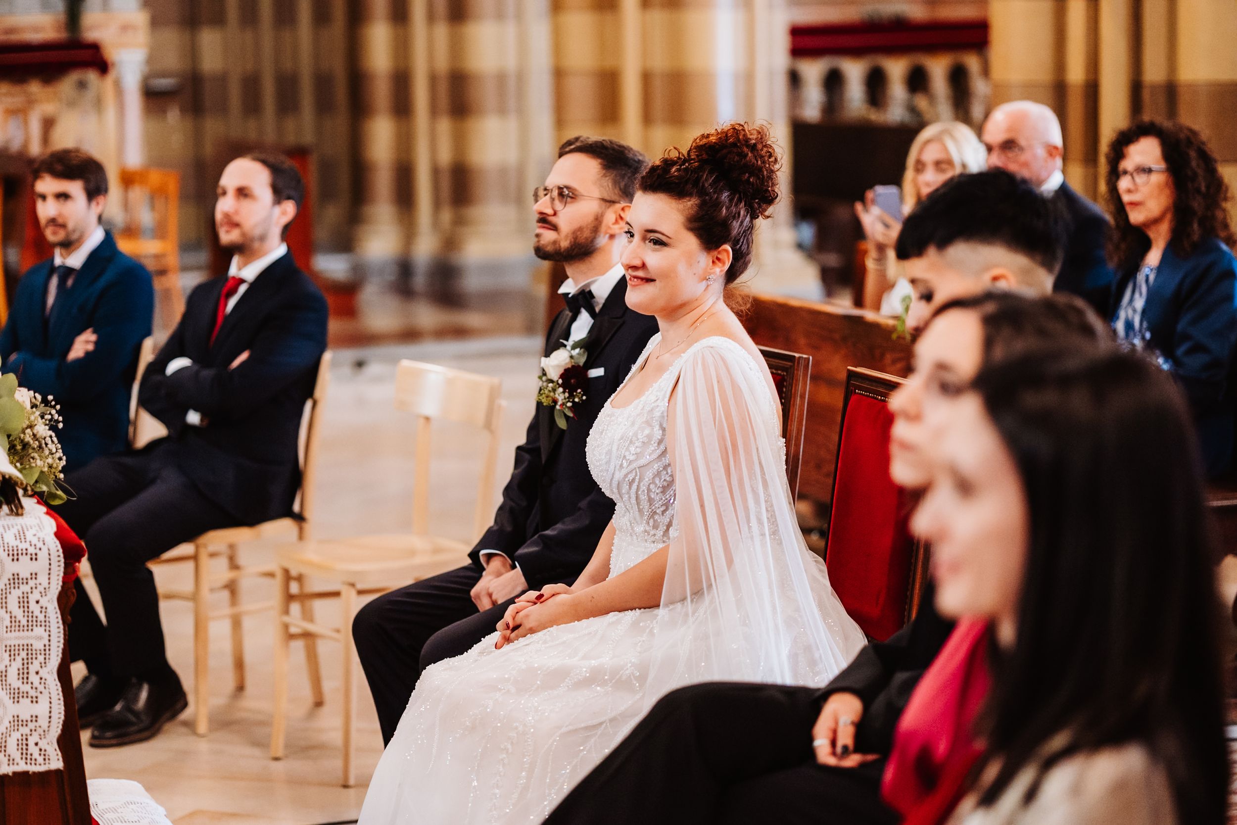 Wedding guests react with laughter and joy during a celebration in an elegant indoor venue.