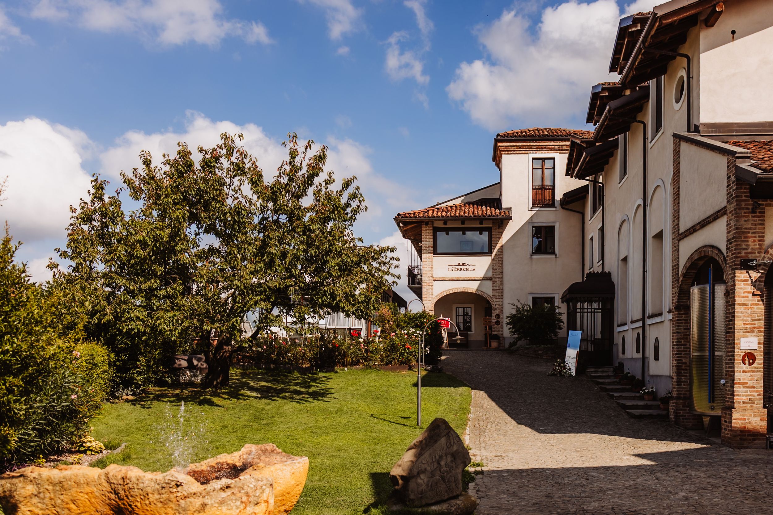 Spanish-style white stucco buildings with red tile roofs line a winding path under blue skies.