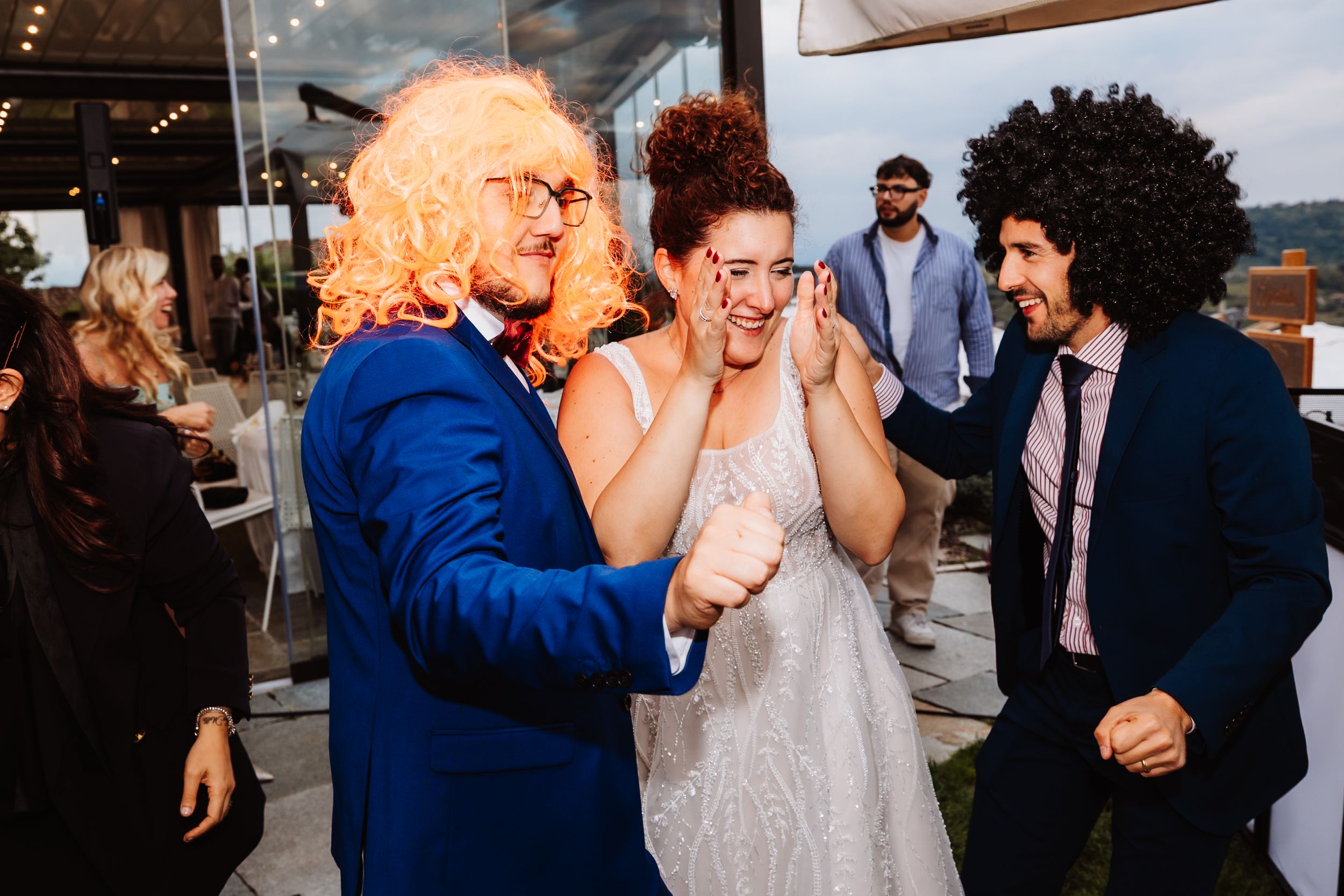 A candid moment of joyful reaction between wedding guests during a celebration at an outdoor venue.