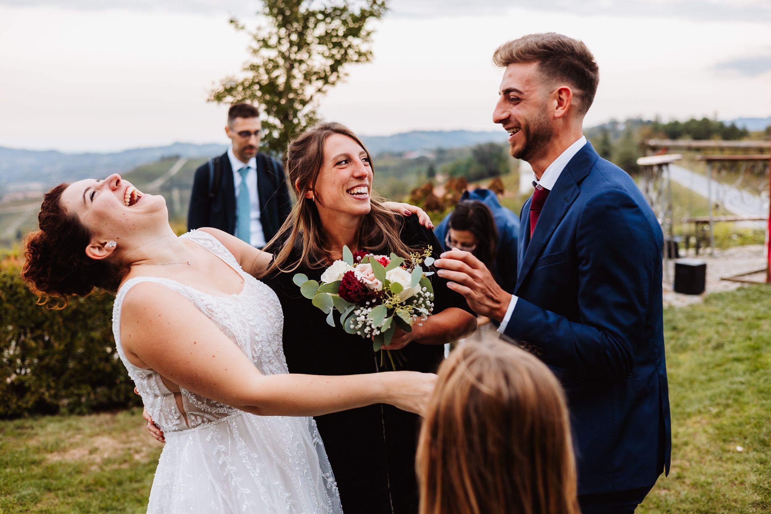 Joyful couple shares a romantic dance together outdoors during their wedding celebration by a scenic waterfront.