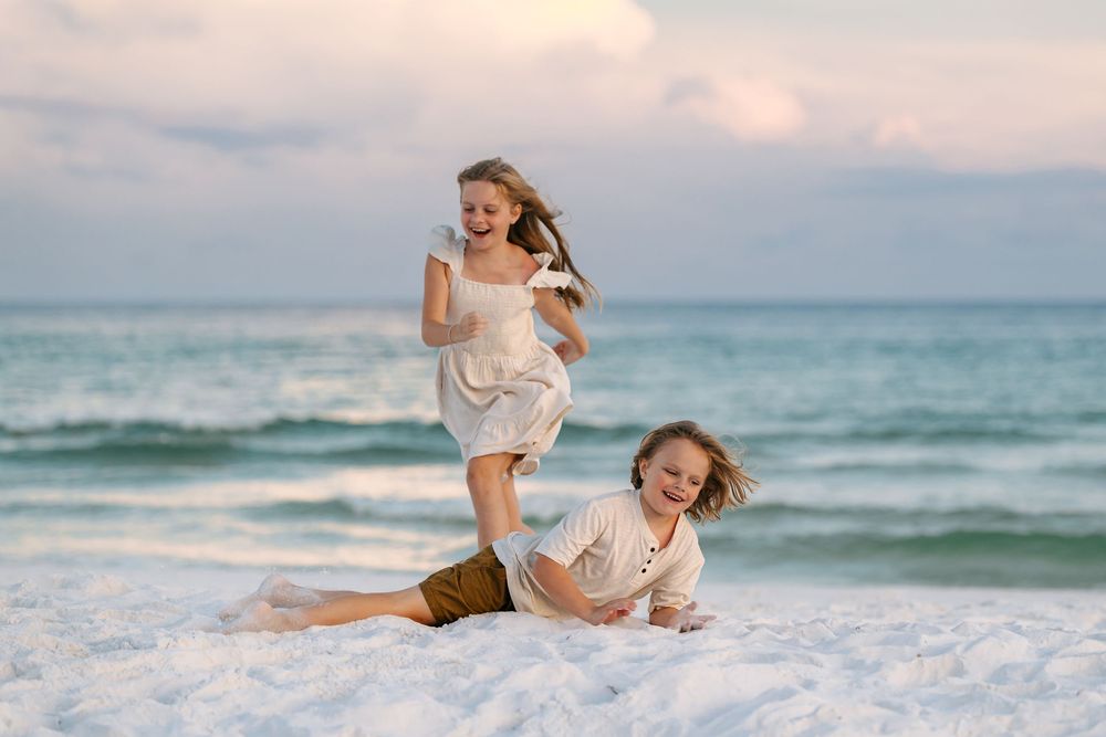 A collection of beachside photos showing people in white outfits enjoying the ocean waves and sandy shoreline at sunset.