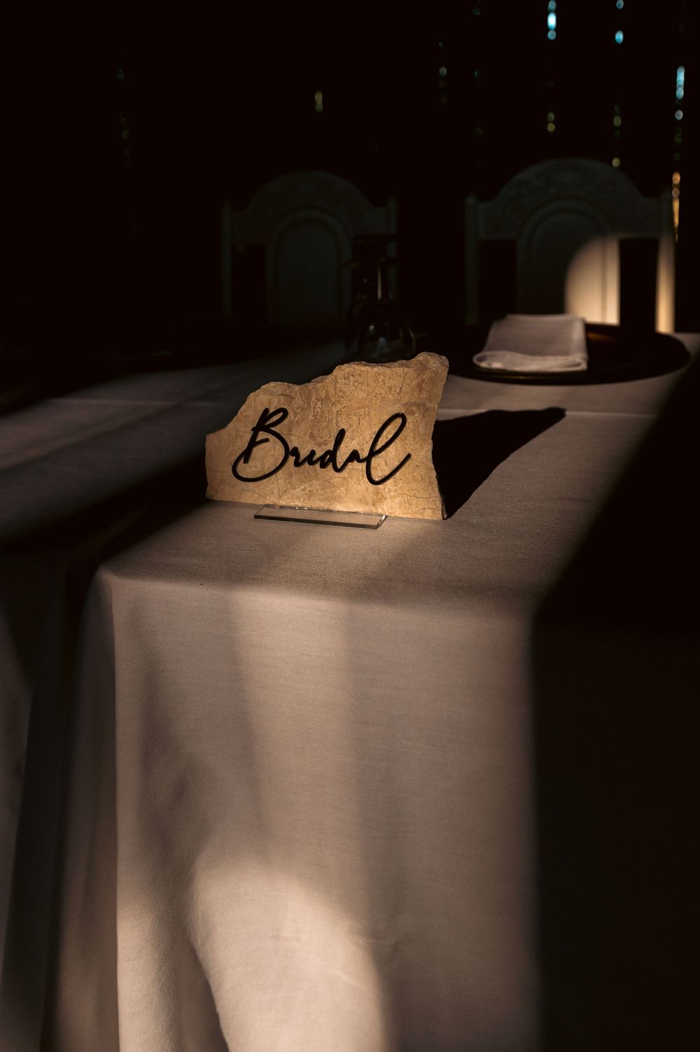 Handwritten name cards displayed in dramatic lighting at a formal event.
