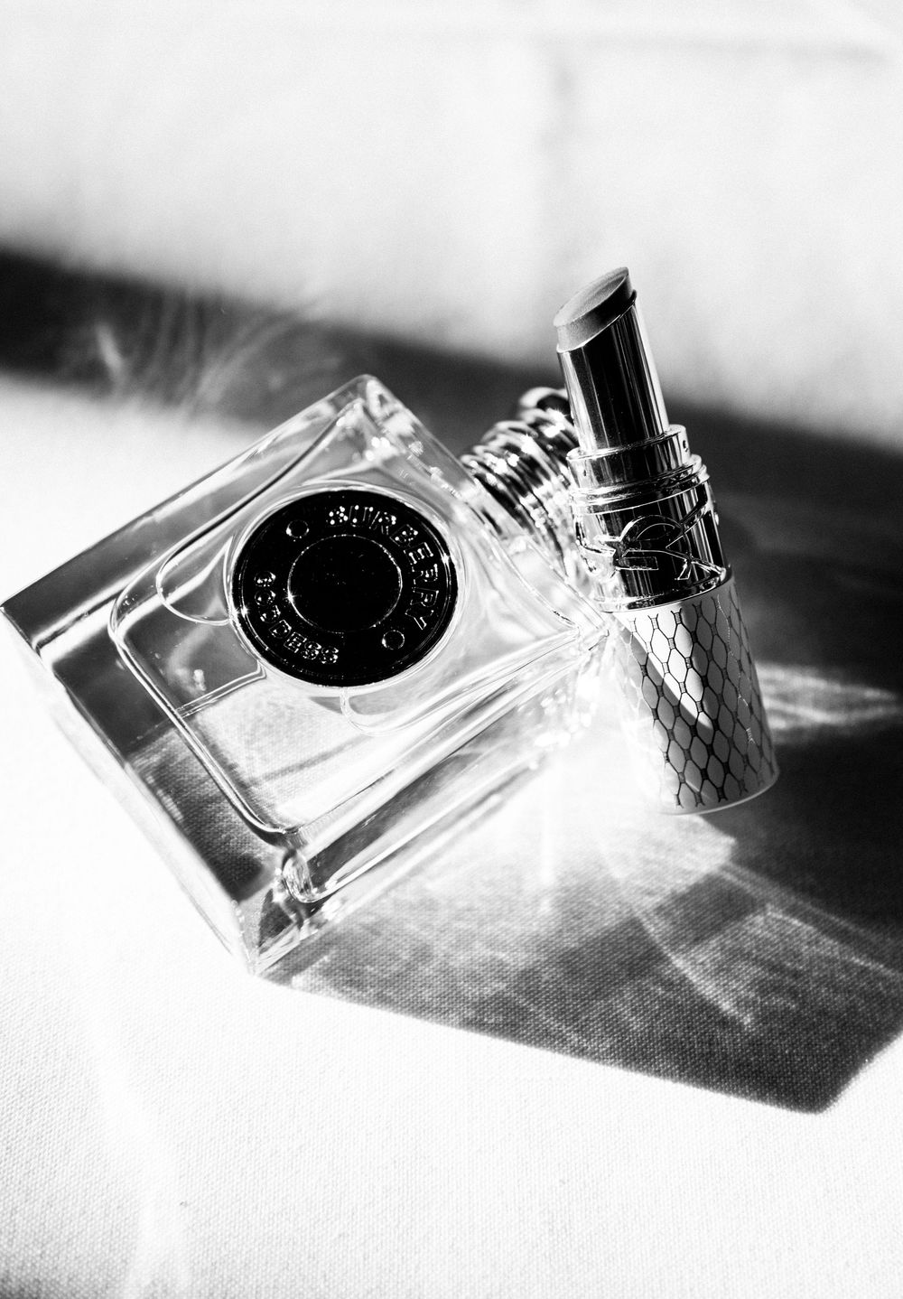 Artistic black and white series of perfume bottles casting dramatic shadows.