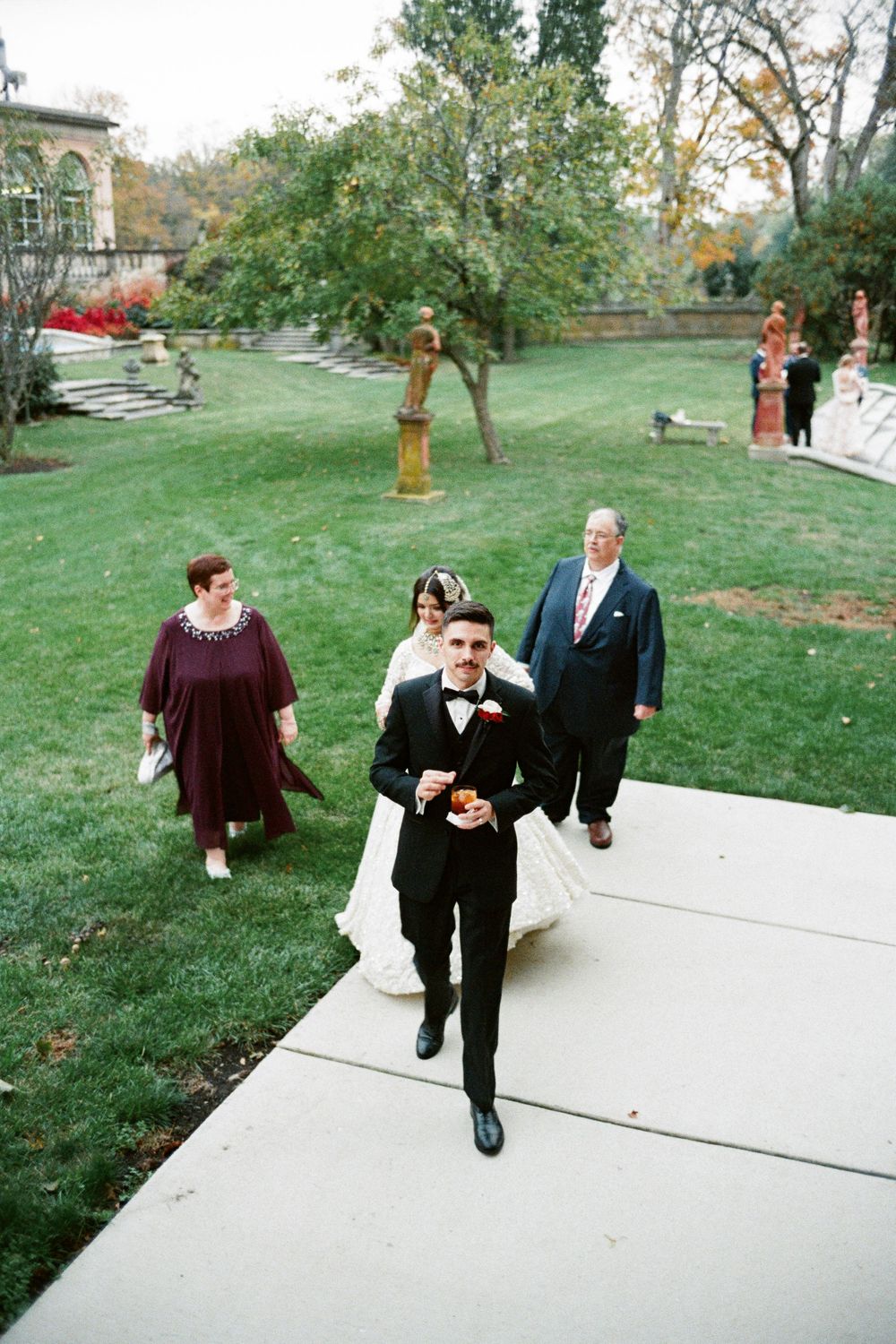 A film photo where a bride and groom approach the cocktail hour at Cuneo Mansion.