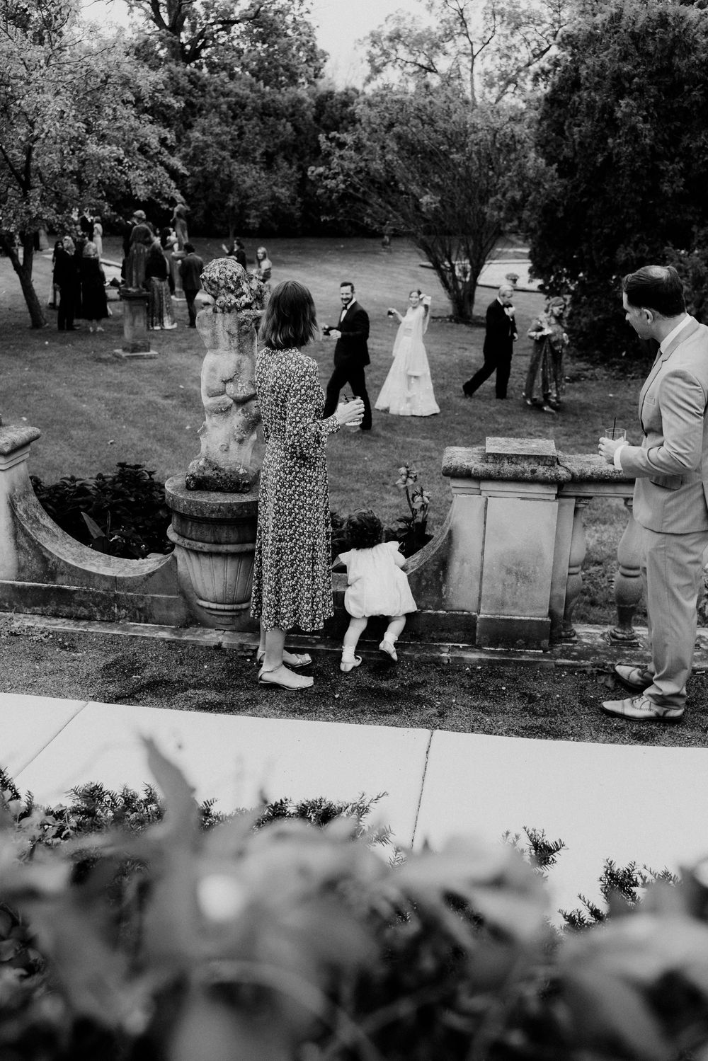A mother and a small child wave to other guests in the Cuneo Mansion Gardens.