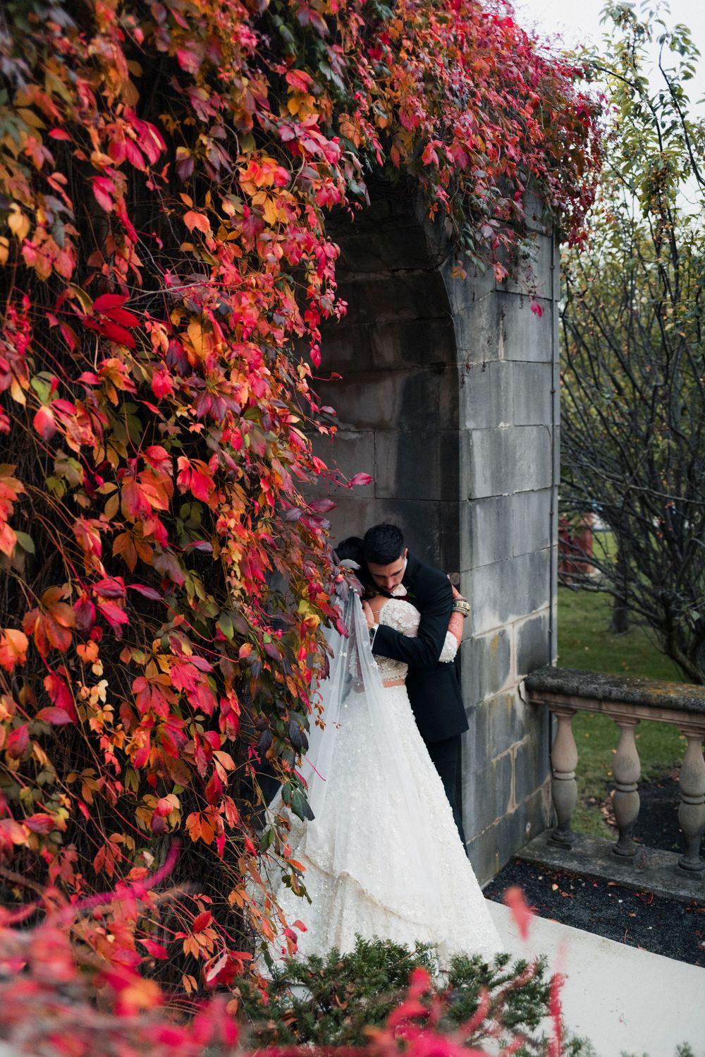 A bride and groom embrace in the garden at a Cuneo Mansion Wedding reception.