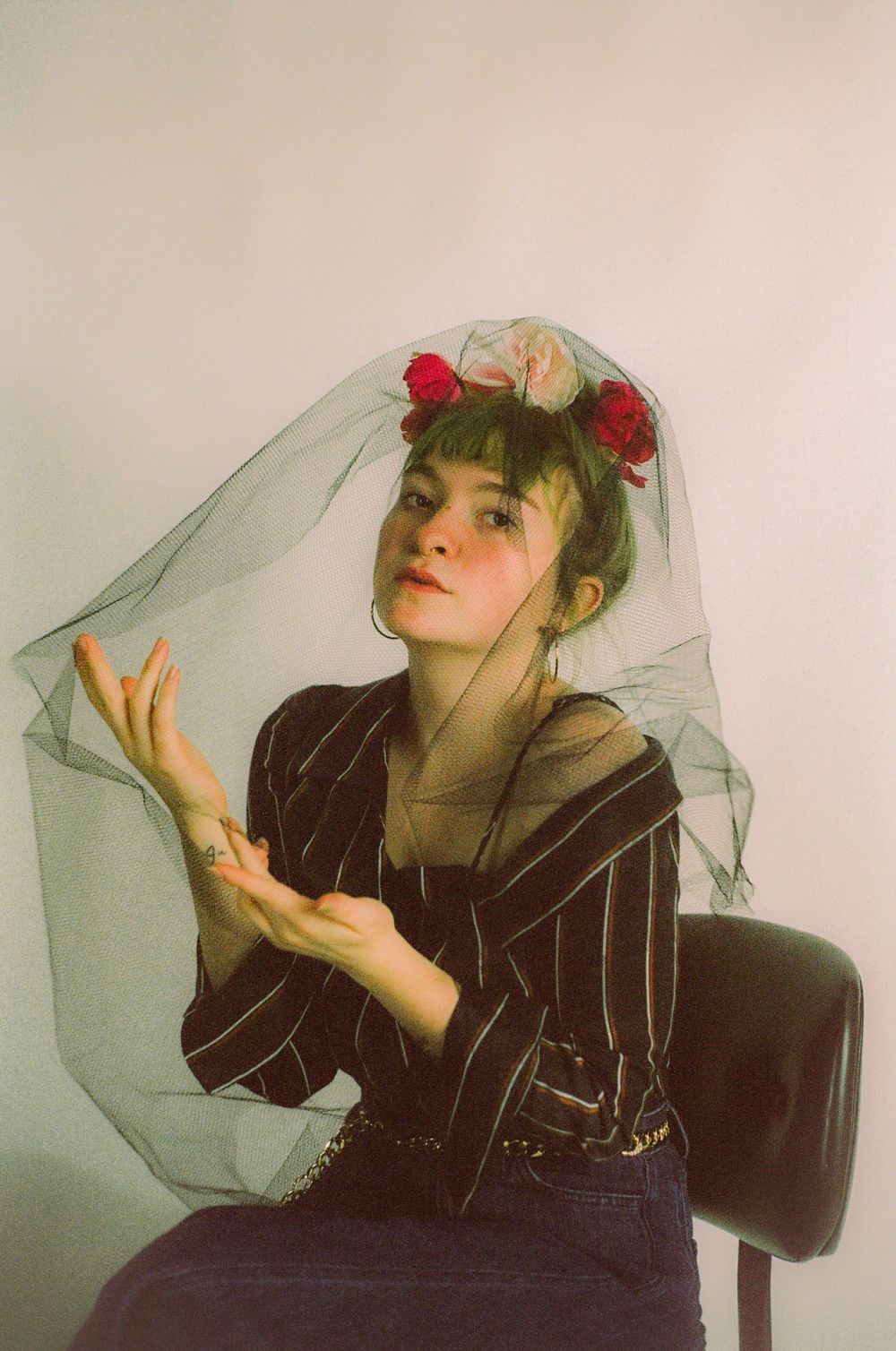 Artistic portrait series featuring ethereal poses with black clothing and sheer veil against light background.