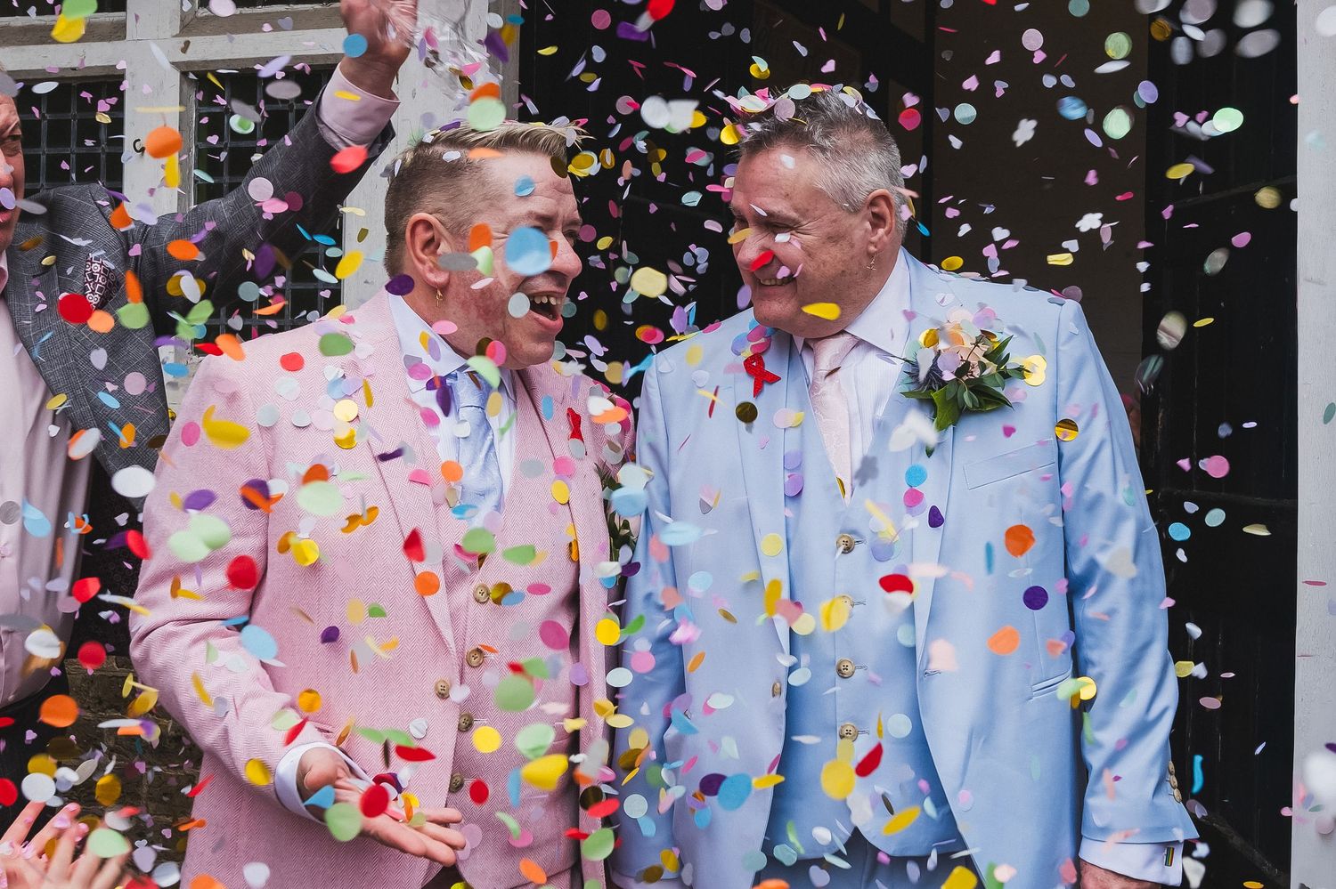 Two grooms enjoy a confetti moment at their London wedding