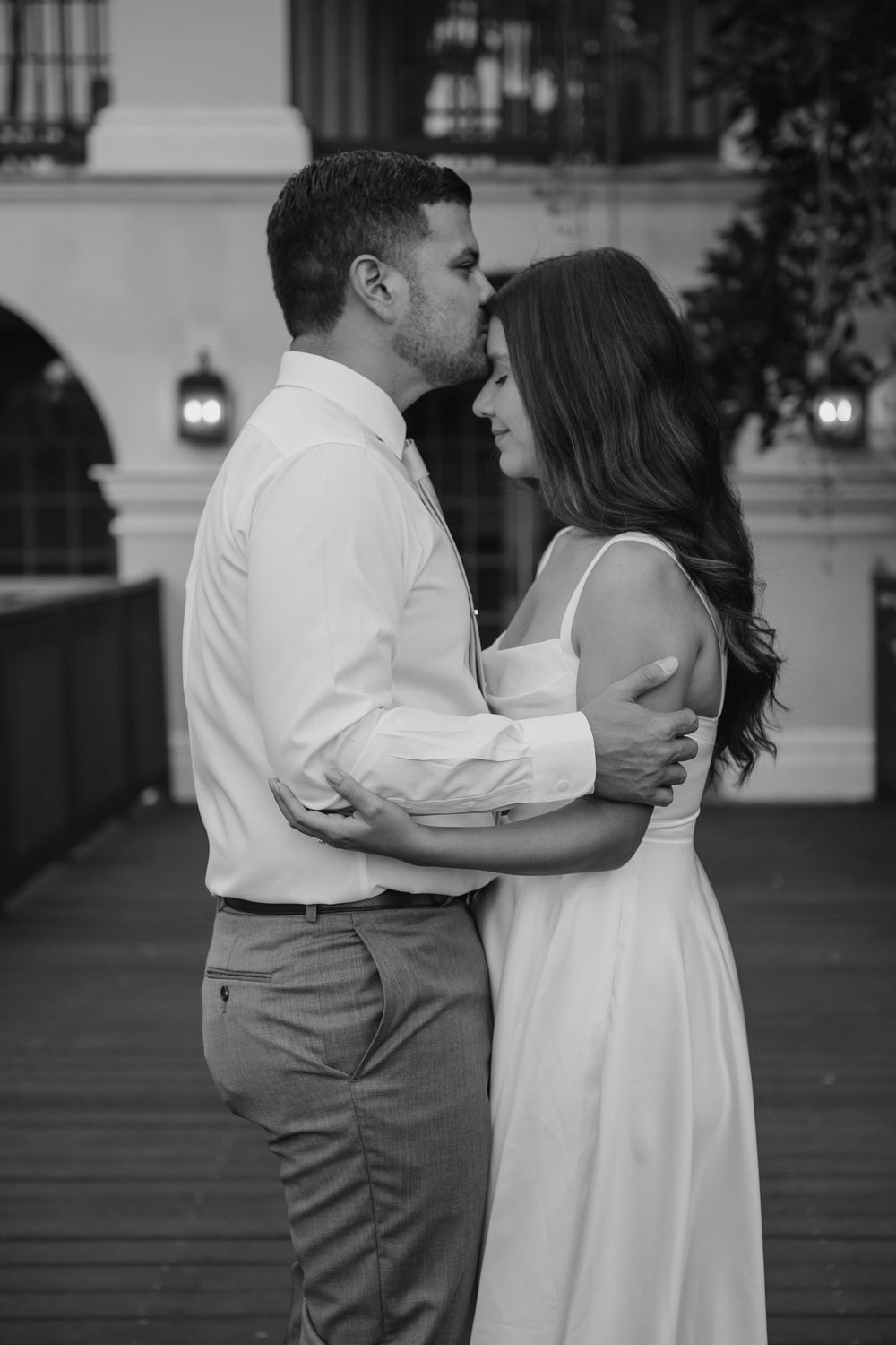 A romantic black and white photo sequence shows a couple in wedding attire sharing intimate moments on a porch.