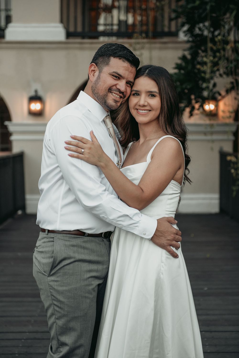 A romantic couple embraces while dancing, with the bride in white and groom in formal attire.