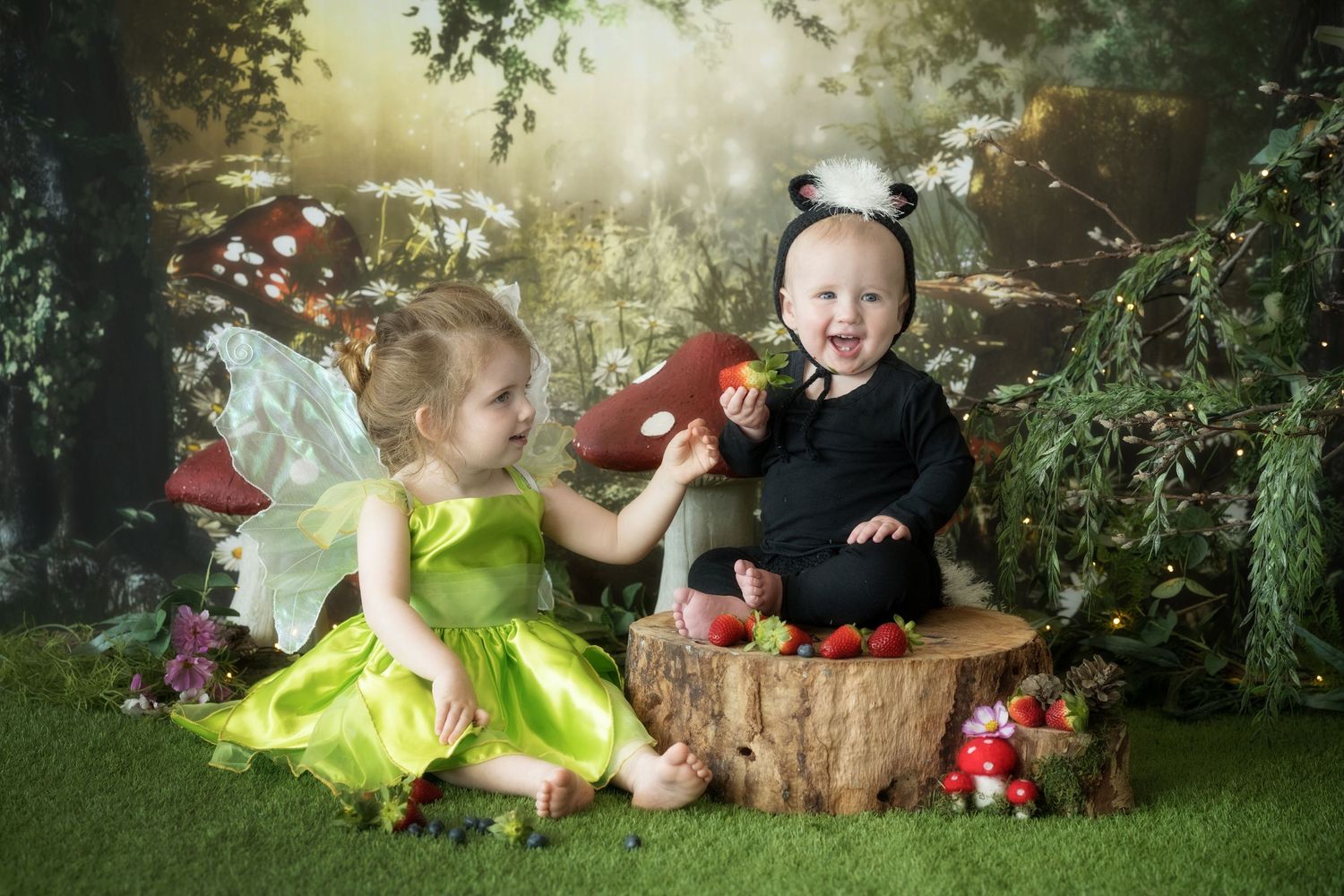Enchanted forest themed photo setup with fairy costumes and woodland decorations.